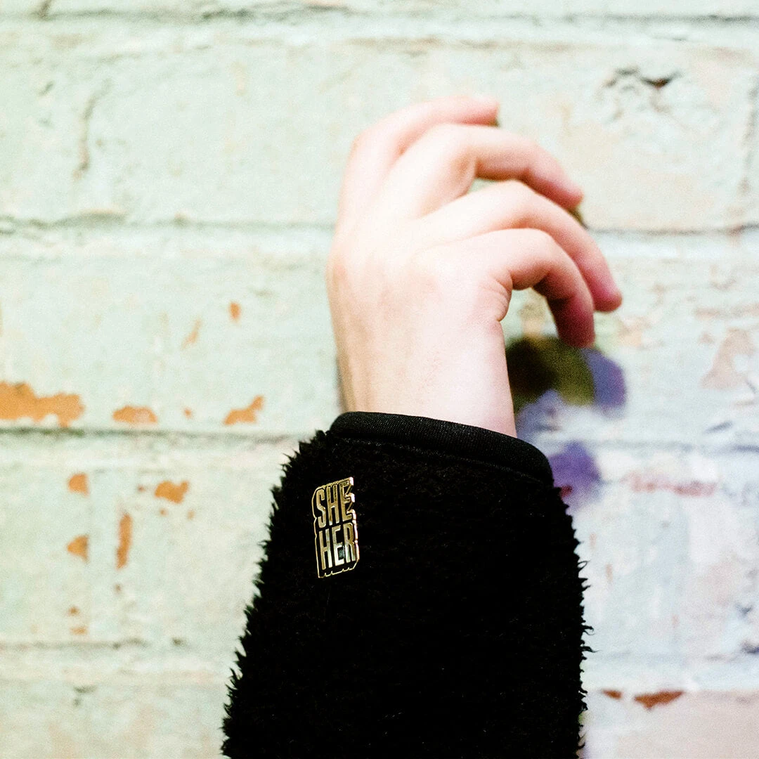 Autostraddle She/Her Pronoun Pin New Merch 3 Autostraddle She/Her Pronoun Pin New Merch