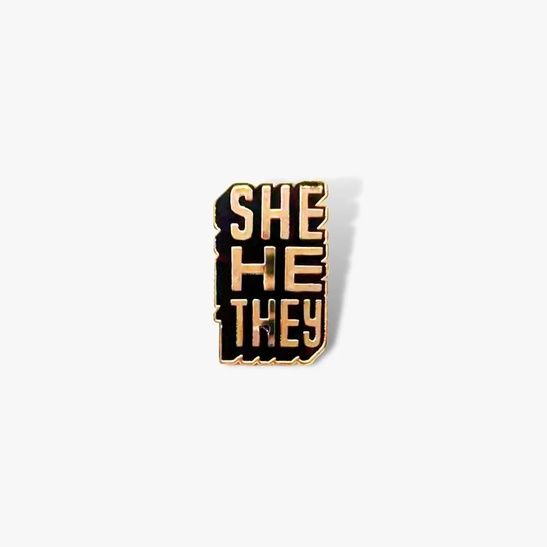 Autostraddle New Merch She/He/They Pronoun Pin 1 Autostraddle New Merch She/He/They Pronoun Pin